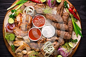 Assorted grilled meat and vegetables on rustic table