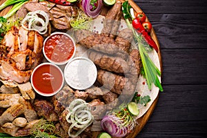 Assorted grilled meat and vegetables on rustic table