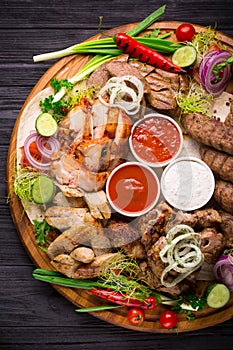 Assorted grilled meat and vegetables on rustic table