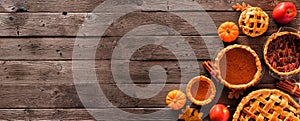 Assorted homemade autumn pies. Pumpkin, apple and pecan. Corner border on a rustic wood banner background.