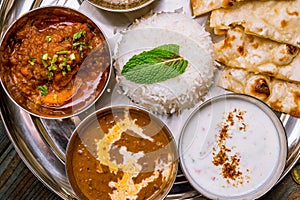 Assorted indian food set on wooden background. Dishes and appetisers of indeed cuisine, rice, lentils, paneer, samosa, spices, mas