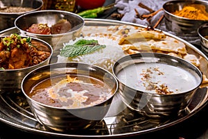 Assorted indian food set on wooden background. Dishes and appetisers of indeed cuisine, rice, lentils, paneer, samosa, spices, mas