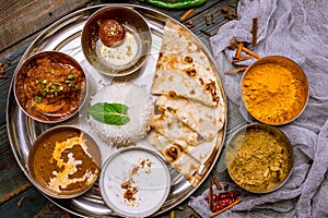 Assorted indian food set on wooden background. Dishes and appetisers of indeed cuisine, rice, lentils, paneer, samosa, spices, mas photo