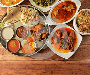 Assorted indian foods pepper chicken gravy,chicken masala and nonveg thali on wooden background. Dishes and appetizers of indian