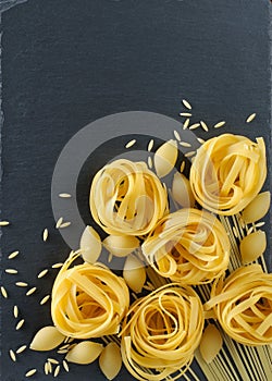 Assorted Italian pasta on grey background