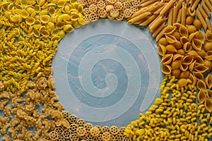 Assorted Italian pasta: Penne rigate, Rotelle, Conchiglie, Cavatappu, Fusilli, Cellentani, horizontal orientation, top view, copy