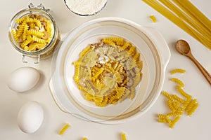 Assorted Italian pasta. On a white background. View from above. Pasta on a plate. Flour, eggs and pasta made from them