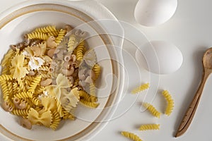 Assorted Italian pasta. On a white background. View from above. Pasta on a plate. Flour, eggs and pasta made from them