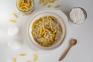 Assorted Italian pasta. On a white background. View from above. Pasta on a plate. Flour, eggs and pasta made from them