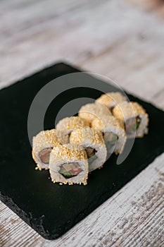 Assorted japanese sushi rolls on black background