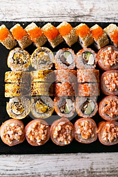 Assorted japanese sushi rolls on black background