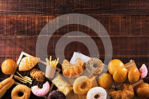 Assorted junk food multiple type on wooden table of top view with copy space