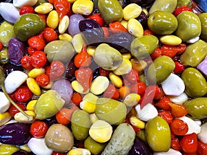 Assorted marinated olives, peppers, small cucumbers and garlic in oil close-up