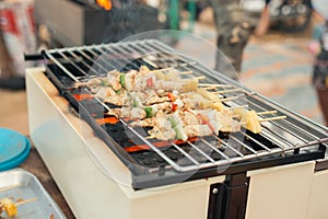 Assorted meat from chicken and pork and various vegetables on barbecue grill cooked.