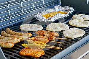 Assorted meat grilling over the hot fire on a portable barbecue with steak, sausage, kebabs, chicken , spare ribs and