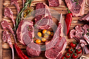 Assorted minced meat ingredients - rack of calf, ribeye, rack of lamb, with garlic, onions, red and yellow tomatoes, red pepper