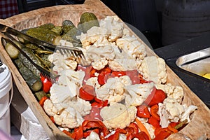 Assorted mix of pickles in sunlight during food festival. Pickled vegetables like red peppers