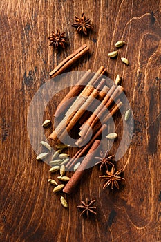 Assorted natural cinnamon, cardamoms and anise stars baking ingredients on a rustic brown