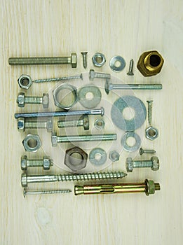Assorted nuts and bolts on a wooden table