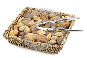Assorted nuts in a wicker basket with a nutcracker