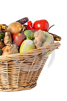 Assorted organic vegetables and fruits in wicker basket isolated on white background. Space for text