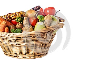 Assorted organic vegetables and fruits in wicker basket isolated on white background. Space for text