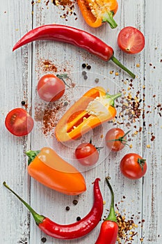 Assorted peppers, cherry tomatoes and spices on light background. Seasonings for food. Homemade spices ingredients for cooking