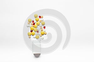 Assorted pharmaceutical medicine pills, capsules and tablets with bottle on white background.