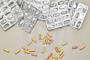 Assorted pharmaceutical medicine pills, tablets and capsules over beige background