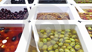 Assorted pickled olives, on the shop counter in a typical public market in Spain