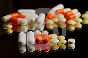 Assorted pills on black table