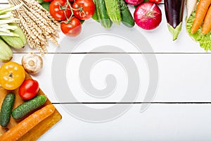 Assorted raw organic fresh vegetables on white wooden table. Fresh garden vegetarian food. Autumn seasonal image of farmer table