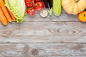 Assorted raw organic fresh vegetables on wooden table. Fresh garden vegetarian food. Autumn seasonal image of farmer table with