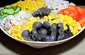 Assorted salad with olives on a plate. Ingredients: chicken meat