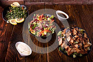 Assorted salads with tomato, cucumber, onion, cabbage, lettuce leaves, lemon slice, spinach and red beans served in dish isolated