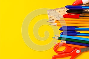 Assorted school supplies on a yellow background