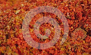 Assorted seasonings in a pile. Background of red paprika powder. Close up of red paprika in a spice shop, texture.