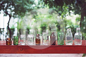 Assorted series collection of empty transparent glass bottle container in white, green and brown color, container reuse concept