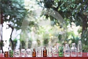 Assorted series collection of empty transparent glass bottle container in white, green and brown color, container reuse concept