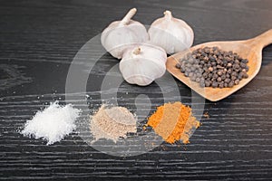 Assorted spices and condiments on table black wooden