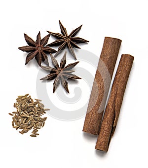 assorted spices isolated on a white background including bay leaves, cardamom pods, coriander seeds, cumin, black peppercorns