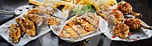 Assorted spicy grilled chicken portions on paper photo