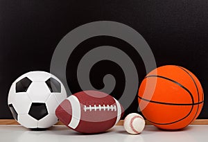 Assorted sports balls with a chalk board