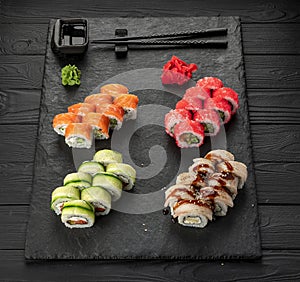 Assorted sushi nigiri and maki big set on slate. A variety of Japanese sushi with tuna, crab, salmon, eel and rolls