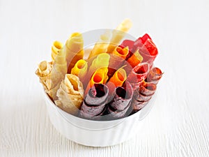 Assorted sweet pureed fruit pastille in bowl. Different dried berries and fruits