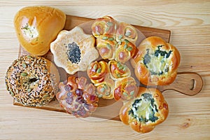 Assorted sweet and savory buns on wooden breadboard
