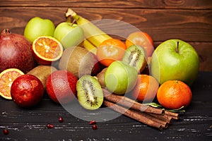 Assorted tangerine kiwi apple orange bananna and pomegranate