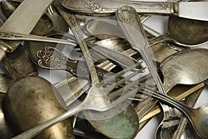 Assorted tarnished antique flatware on white