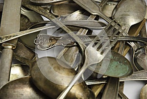Assorted tarnished antique flatware on White