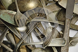 Assorted tarnished antique flatware on White photo